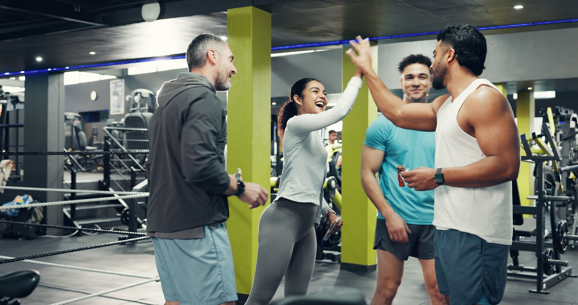 Fitness, group and high five with support at gym for exercise progress, training milestone and happy. Sports club, people and celebration for teamwork goals, workout achievement or health motivation